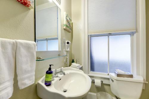 a bathroom with a sink and a toilet and a window at Broad Street Inn in Nevada City