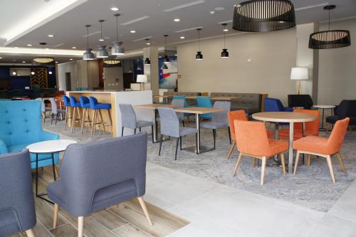 a restaurant with tables and chairs and a bar at La Quinta Inn & Suites Katy-Mills by Wyndham Katy in Katy