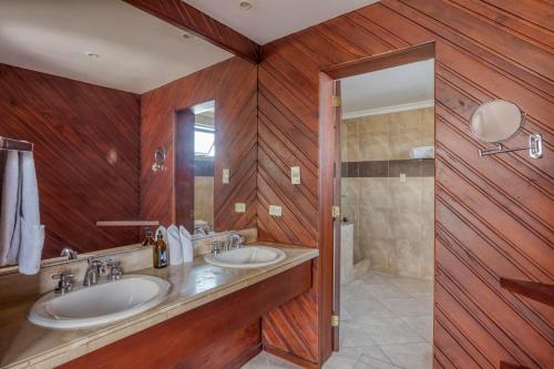 baño con 2 lavabos y paredes de madera en Selina Quito, en Quito