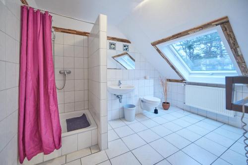 baño con cortina de ducha rosa y aseo en Strandhotel Weißer Berg en Neustadt am Rübenberge