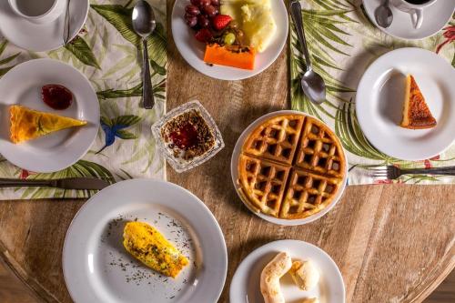 Solar Da Serra Tiradentes في تيرادينتيس: طاولة مليئة بأطباق الطعام والفطائر