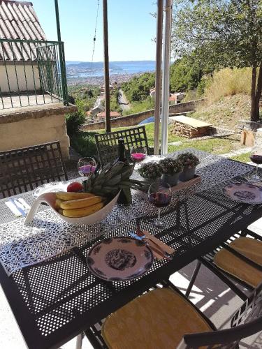 a table with a bowl of fruit and wine glasses at Holiday Home Miklica in Klis