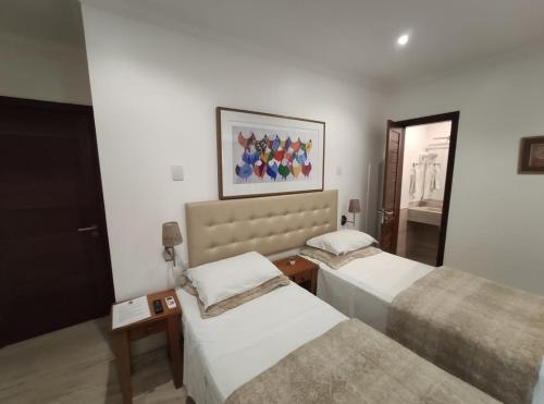 a room with two beds and a picture on the wall at Pousada Bahia Pelô in Salvador