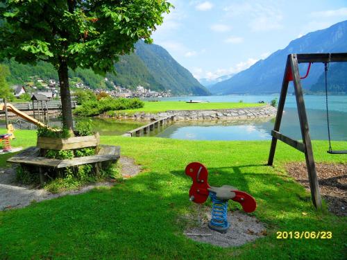 a playground with a swing and a toy in the grass at Apartment Silvia Cijan in Hallstatt