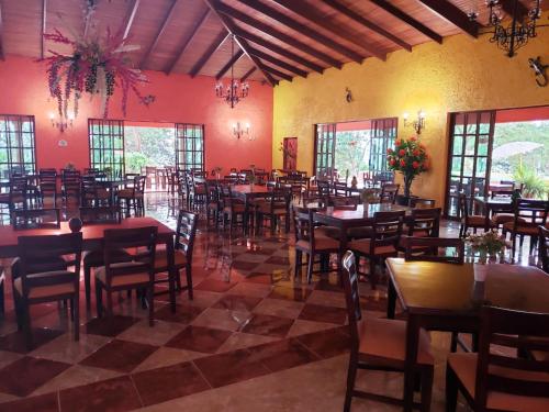 a restaurant with tables and chairs in a room at Hotel Hacienda Prom in Misantla