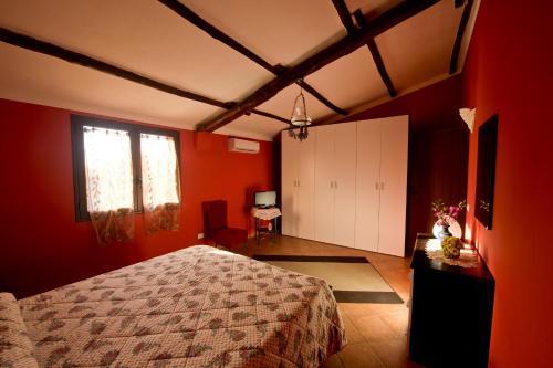 a bedroom with red walls and a bed and a window at La Mimosa Case Vacanze in Marsala
