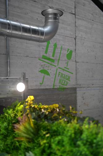 a sign on the side of a building with plants at Ibis Madrid Getafe in Getafe