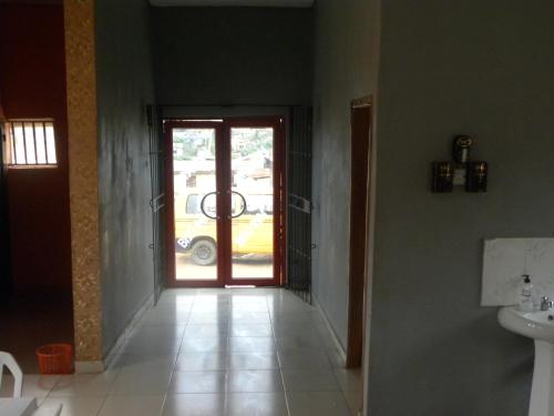 einen Flur mit einer Tür und ein Badezimmer mit einem Waschbecken in der Unterkunft Biso Inn in Alimosho