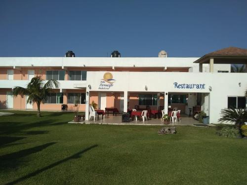 a building with a restaurant with a lawn in front of it at Hotel Arrecife Chachalacas in Chachalacas
