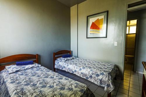 Pokój z dwoma łóżkami i zdjęciem na ścianie w obiekcie Apartamento Praia Litoral Piauí w mieście Luis Correia