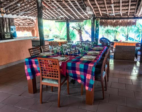 a long table with chairs and wine glasses on it at Casa Bonita and villas in Isla Mujeres