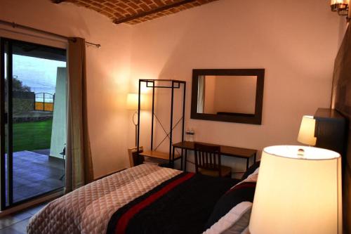 a bedroom with a bed and a table and a mirror at Casa Bravía - Hotel·RV in San Luis Soyatlán