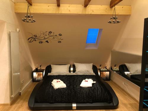 a bedroom with a black bed with two towels on it at CATS Dreams in Bottrop