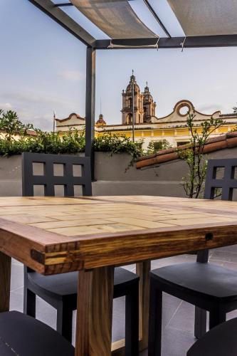 a wooden table and chairs with a view of a building at Arawi Hotel Boutique in Valle de Bravo