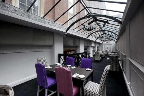 a dining room with tables and purple chairs at St James Hotel; BW Premier Collection in Nottingham