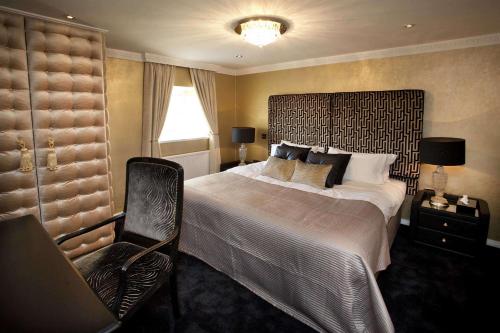 um quarto com uma cama grande e uma cadeira em St James Hotel; BW Premier Collection em Nottingham