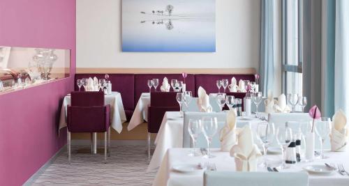 a dining room with white tables and purple walls at Best Western Plus Welcome Hotel Frankfurt in Frankfurt