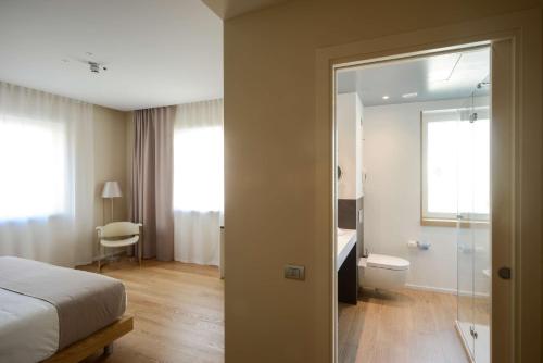 a bedroom with a bed and a bathroom with a shower at Best Western Plus Hotel Bologna in Mestre