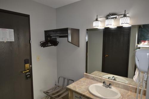 a bathroom with a sink and a mirror at Countryside Inn & Suites Omaha East-Council Bluffs IA in Council Bluffs