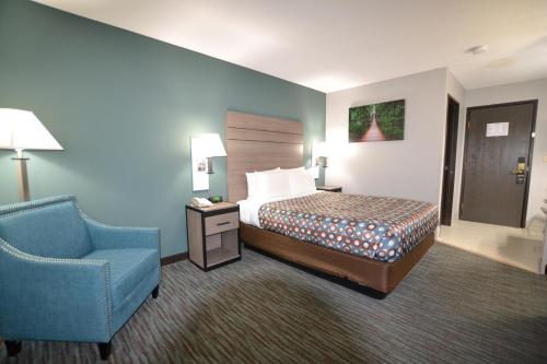 a hotel room with a bed and a blue chair at Countryside Inn & Suites Omaha East-Council Bluffs IA in Council Bluffs