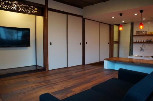 a living room with white cabinets and a tv at Moon's Cafe in Onomichi