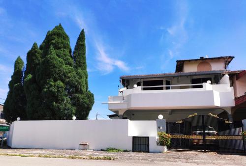 a white house with a fence and a tree at LOW SEASON PROMOTION! 4B12B max 25 pax Party House in Ipoh