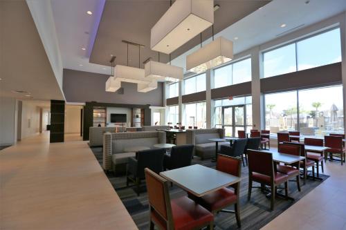 a restaurant with tables and chairs and windows at Holiday Inn Express & Suites Houston NW - Hwy 290 Cypress by IHG in Cypress
