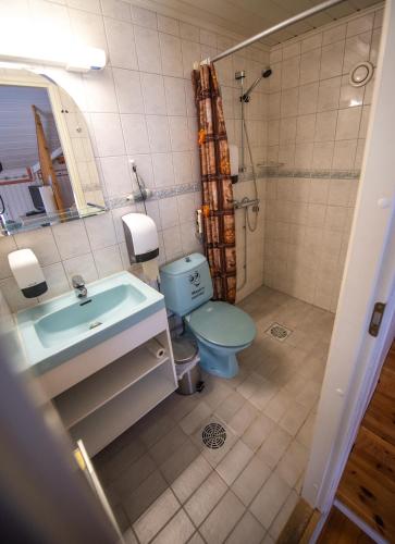 a bathroom with a blue toilet and a sink at Holiday Village Kuukiuru in Vuostimo