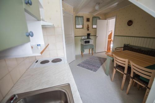 a small kitchen and dining room with a table at Holiday Village Kuukiuru in Vuostimo