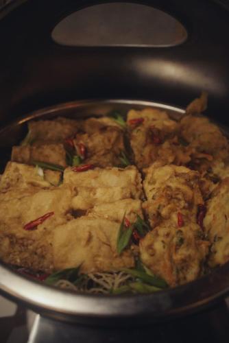 a pan of food is cooking on a stove at Ayani Hotel Banda Aceh in Banda Aceh