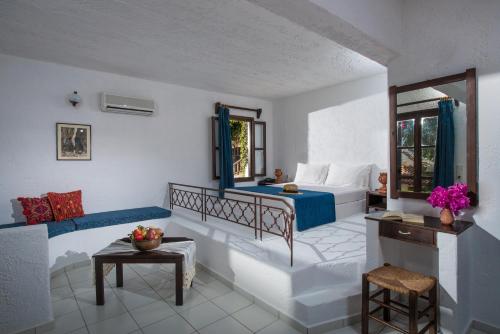 een slaapkamer met een bed en een bank in een kamer bij Ambelos in Agia Pelagia