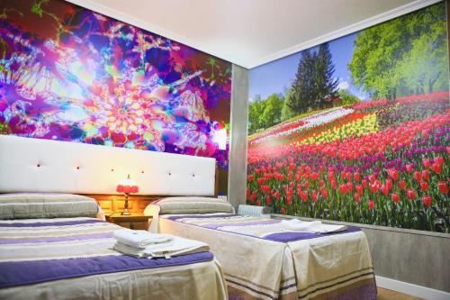 Habitación con 2 camas y una gran pintura de flores. en Hotel plaza, en Riaza