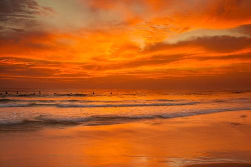 a group of people in the ocean at sunset at Royal Rich Villa in Ambalangoda