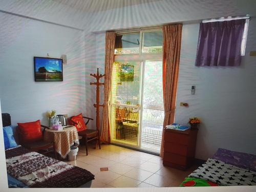 a room with a window and a bed and a table at Fire B&B in Chishang