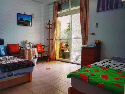 a bedroom with two beds and a large window at Fire B&B in Chishang
