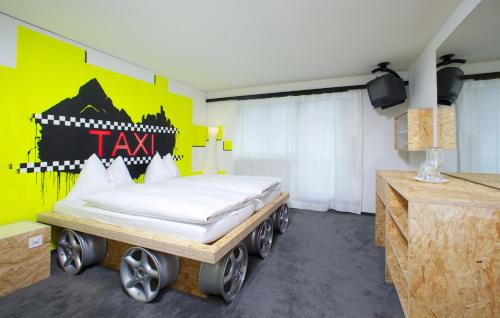 a bed on a wagon in a room with a yellow wall at Arena Lodge in Flims