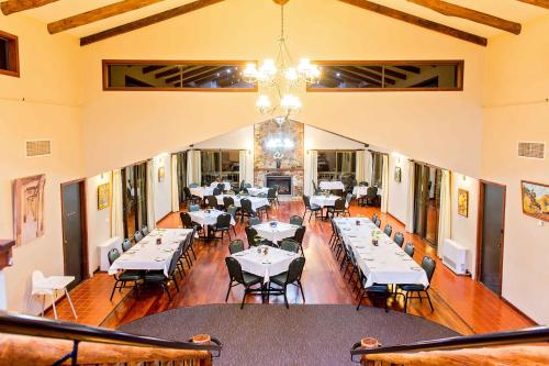 a dining room with tables and chairs and a chandelier at Evedon Lakeside Retreat in Burekup