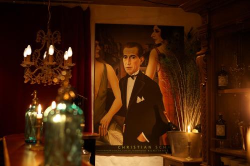 a picture of a man in a suit in front of a painting at Arena Lodge in Flims