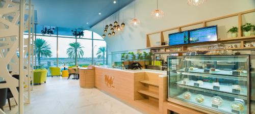 Swiss-Belinn Airport Muscat Oman في مسقط: مطعم مع خزانة عرض في الغرفة