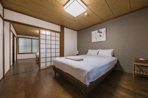 Un dormitorio con una cama grande y una ventana en Shiki Homes NENE, en Kioto