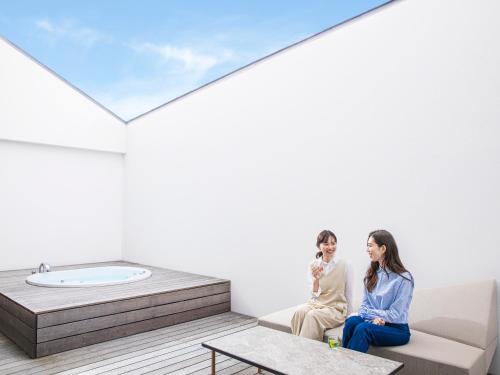 a man and a woman sitting on a couch in a room at Garden Terrace Saga Hotel & Resorts in Saga