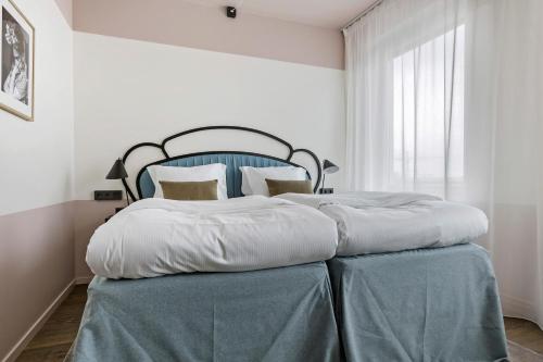 a bedroom with a large bed with a blue headboard at Hotel Giò; BW Signature Collection in Solna