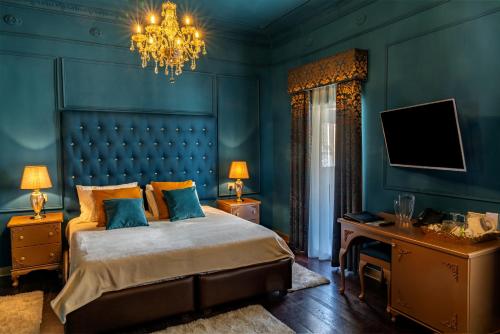 a blue bedroom with a bed and a chandelier at Julina Boutique Living in Mosta