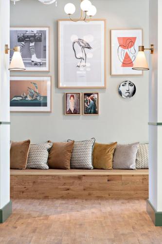a bench in a room with pictures on the wall at Hotel Giò; BW Signature Collection in Solna