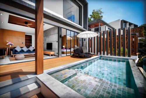 a house with a swimming pool in the backyard at Jamahkiri Dive Resort & Spa in Koh Tao