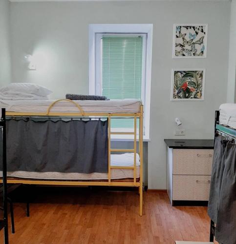 a bedroom with a bunk bed and a window at Capsularhouse Hostel in Dnipro