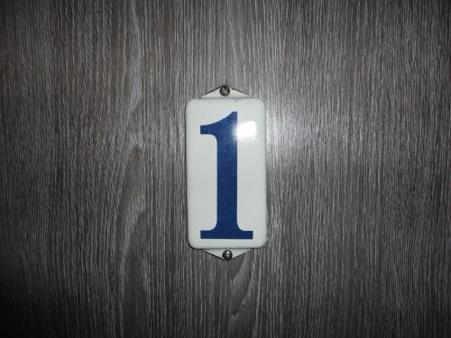 a sign with the number one on a wooden wall at De Vier Seizoenen in Renesse
