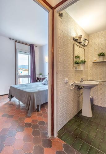 a bedroom with a bed and a sink in a room at Goldhome - Port Petit - Casa 4 habitaciones, amarre, wifi, aire acondicionado in Empuriabrava