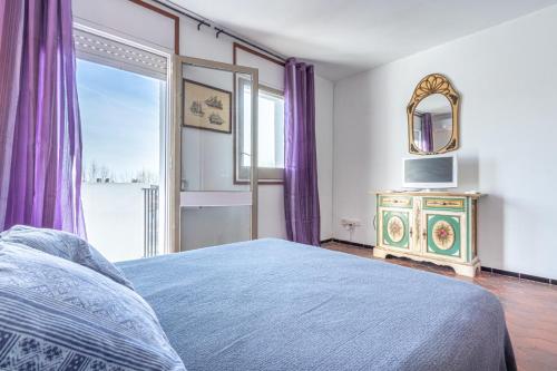 Un dormitorio con una cama, una ventana y un espejo. en Goldhome - Port Petit - Casa 4 habitaciones, amarre, wifi, aire acondicionado, en Empuriabrava