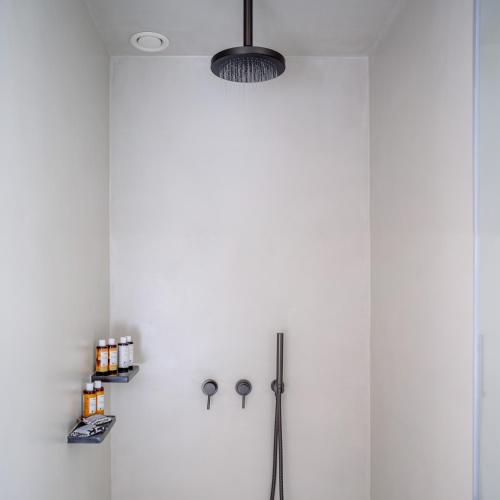 a white kitchen with a refrigerator and a light fixture at Potnia Theron Suites in Akrotiri